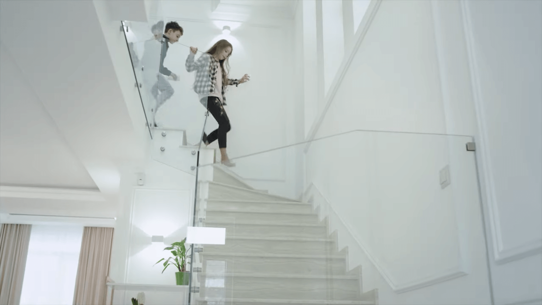 Children coming down a modern glass staircase